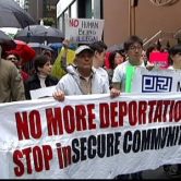 Protesters with sign reading "No more deportations, stop insecure communities"