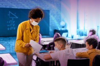 Teacher looking at assignment with two students